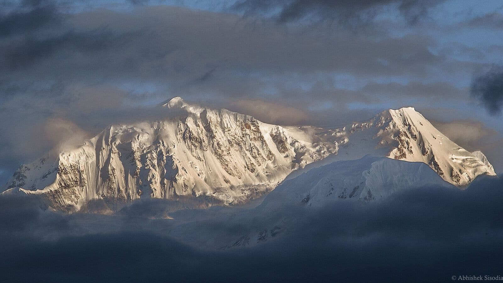 Snow peaks of the high Himalaya beneath heavy sky