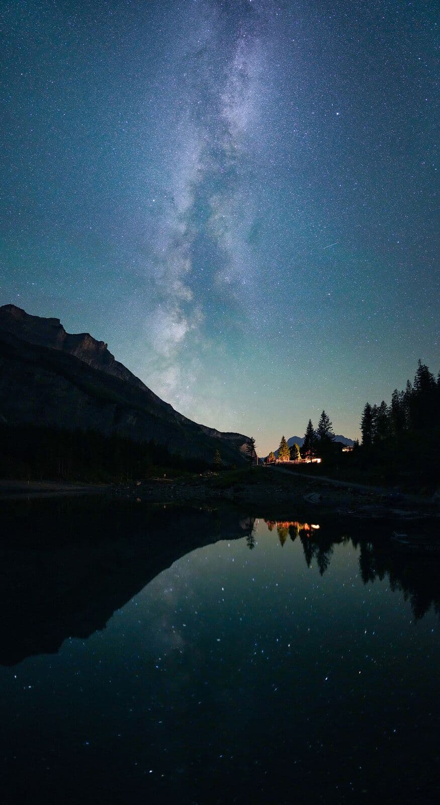The Milky Way reflected over a still mountain lake